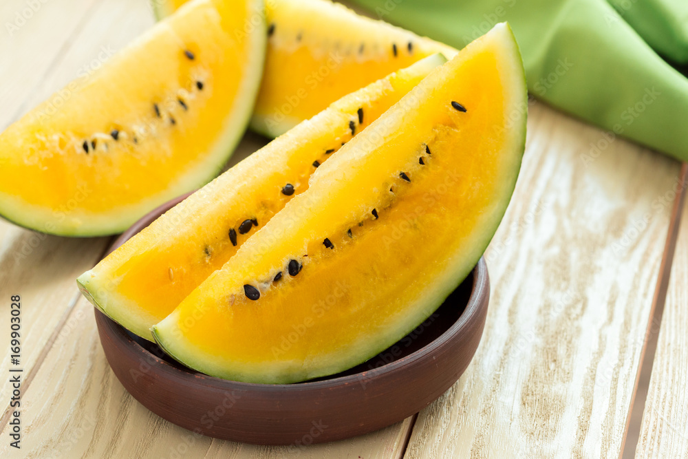 Yellow watermelon sliced on wooden background Yellow watermelon sliced on wooden background