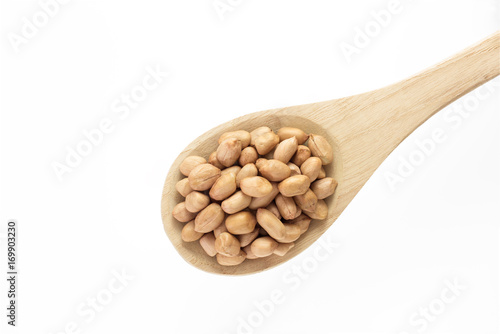 Raw peanut with wooden spoon on white background.