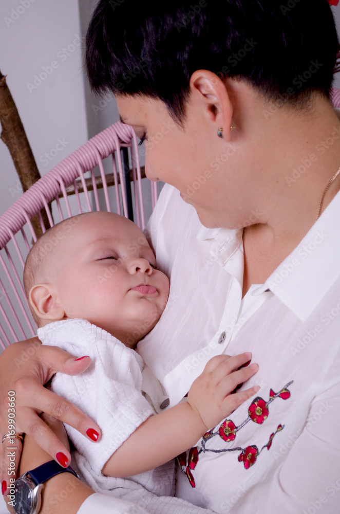 Happy mother with sleeping newborn baby