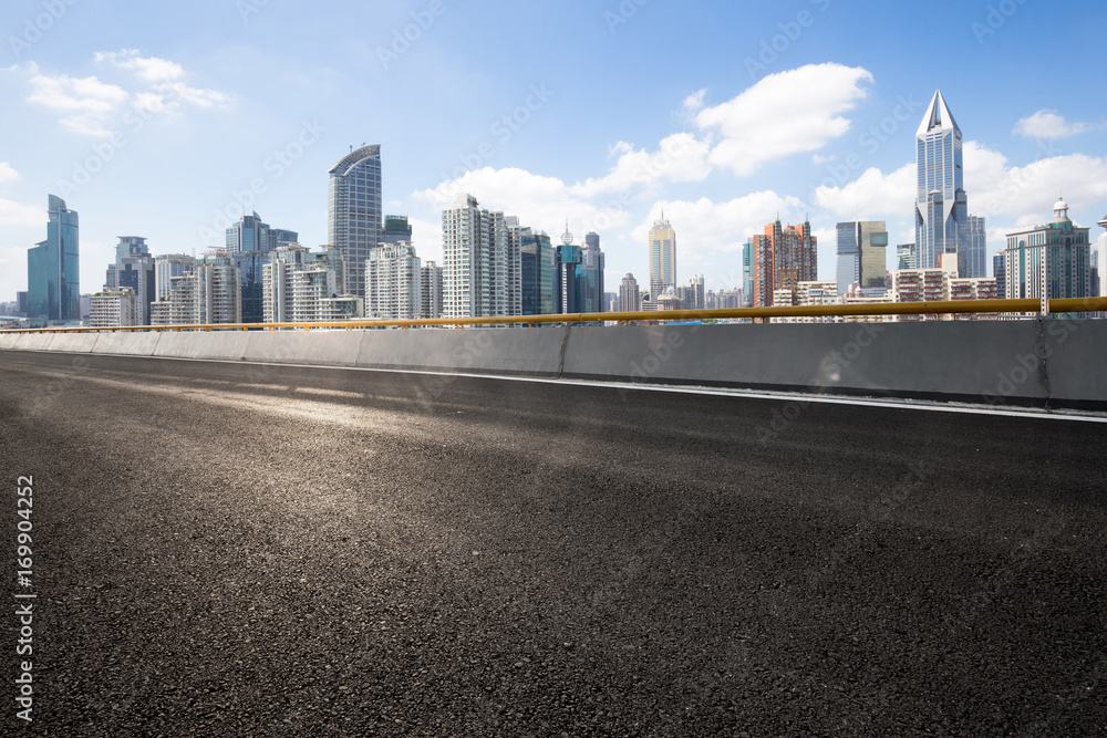 empty asphalt road with cityscape of modern city in blue sky empty asphalt road with cityscape of modern city in blue sky