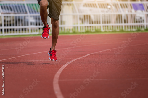 man running in the track. Fit male fitness runner jogging in stadium