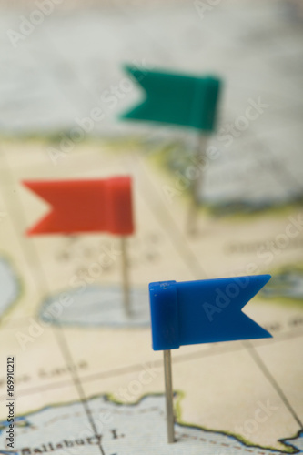 Flag shaped push pin in a vintage travel map. travel destination planning concept