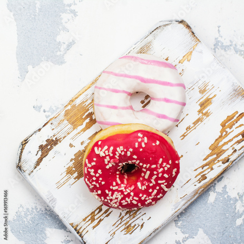 Sweet pink and white donuts on white background. Copy space photo