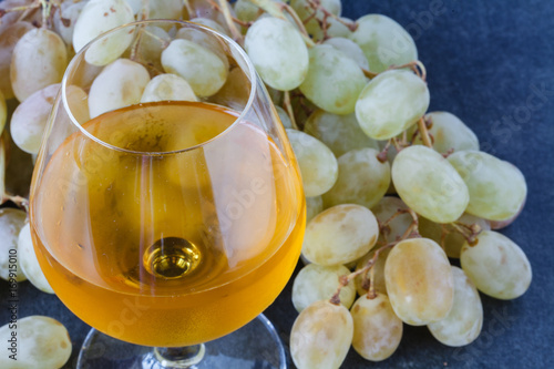 White wine in a glass with fall grapes photo