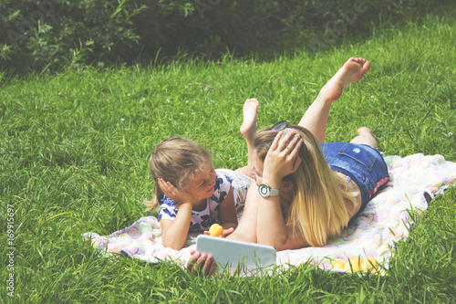 mother and daughter in the Park and watch on your tablet photo