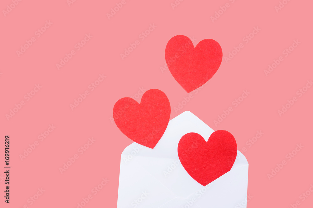 Red heart in a white envelope on a pink background.