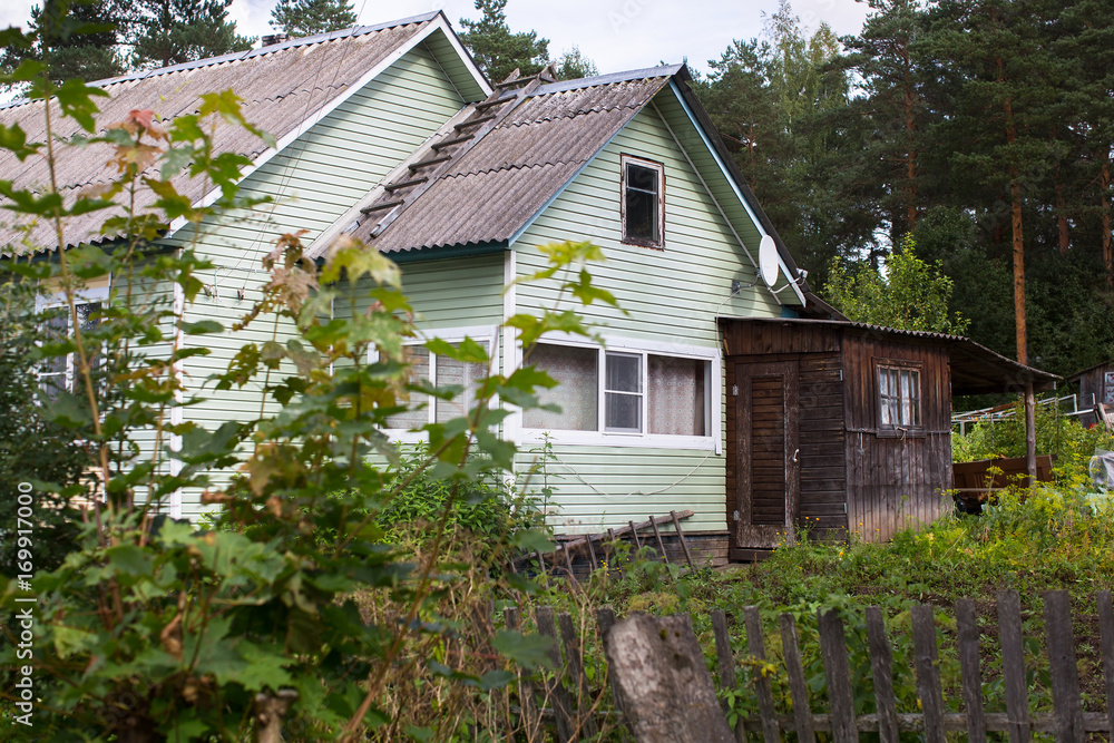 A typical residential wooden house in settlement in Leningrad region, Russia. A typical residential wooden house in settlement in Leningrad region, Russia.