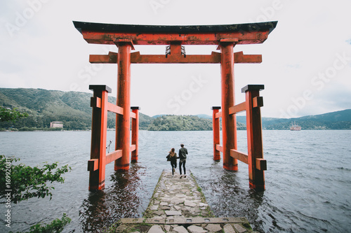 Back view of a young hipster couple at Itsukushima Shrine, Japan photo