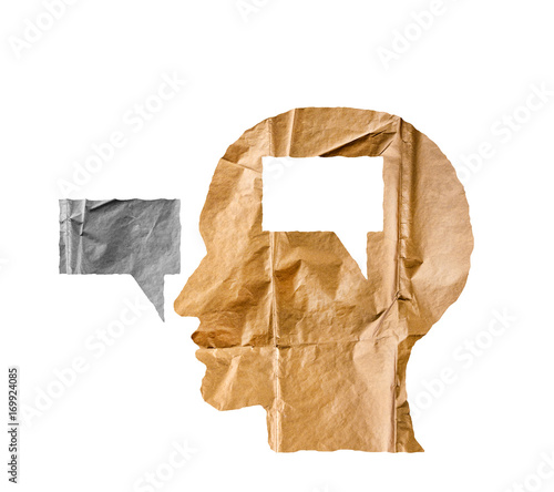 Crumpled paper shaped as a human head and talk balloon on white. photo