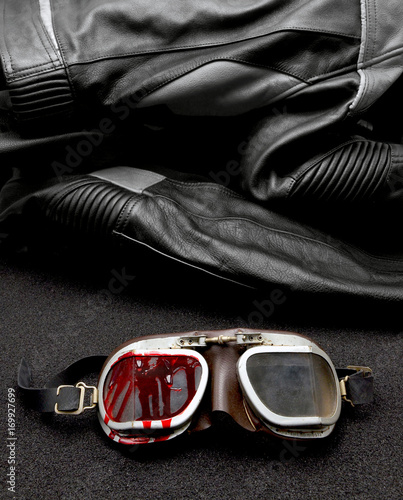 old Motorcycle glasses with blood and jacket behind Fototapeta