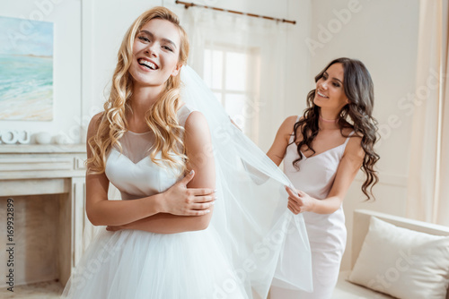 bridesmaid preparing bride for ceremony