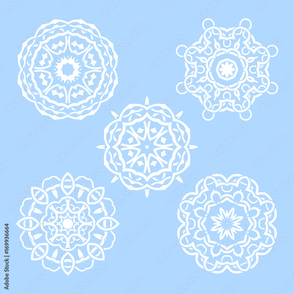 Vector set of five round snowflakes. Illustration of white mandalas on blue background Vector set of five round snowflakes. Illustration of white mandalas on blue background