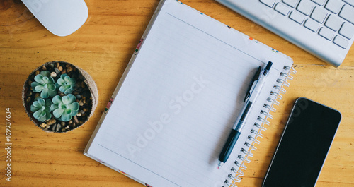 top view of office desk for creative with empty notebook