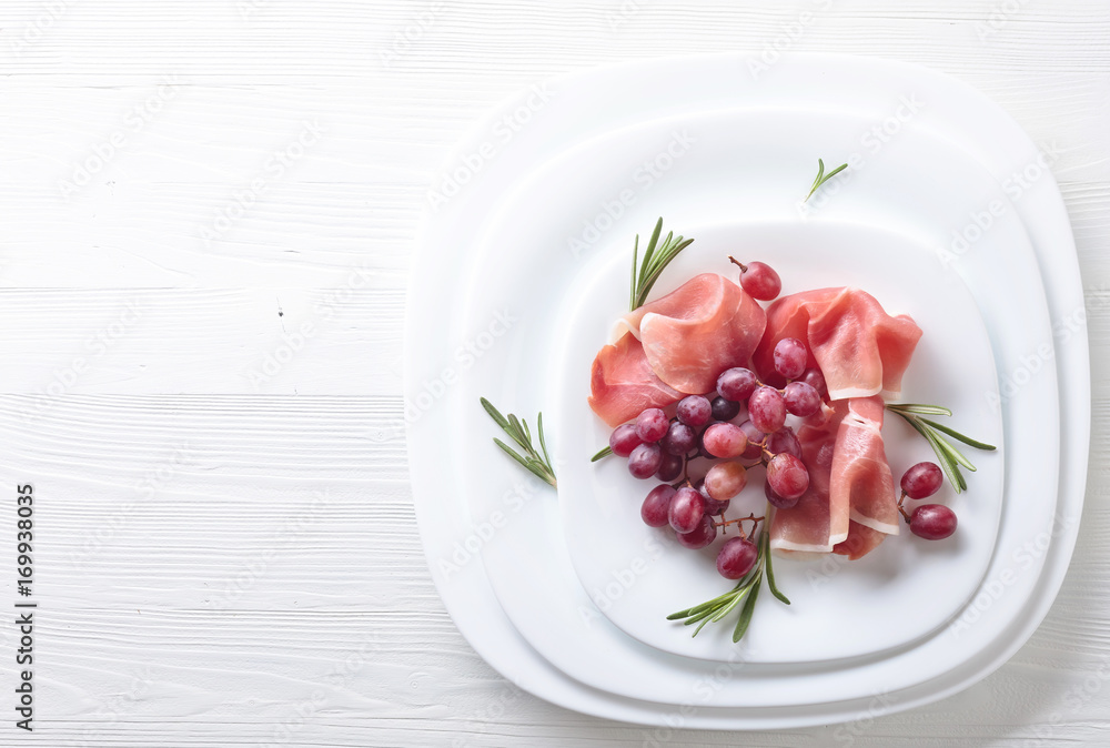 Jamon serrano with rosemary and grape . Jamon serrano with rosemary and grape .