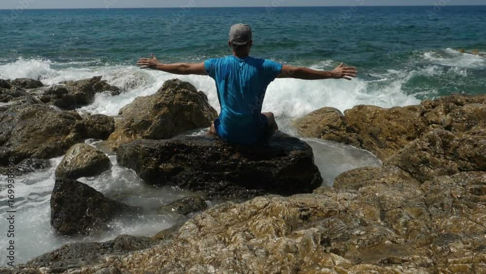 Man looking at sea and showing freedom while sea storm.
Man looking at sea and showing freedom while sea storm.