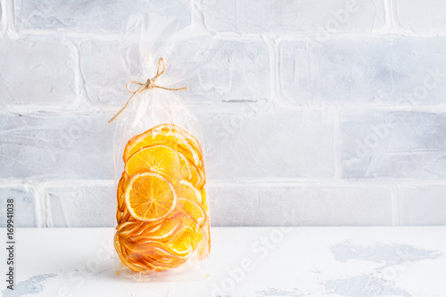Sunny orange slices in a cellophane bag. Edible present. Copy space photo