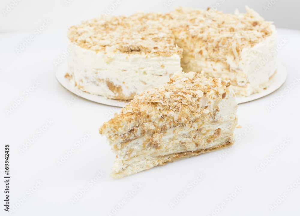 Piece of cake on the background of a whole cake