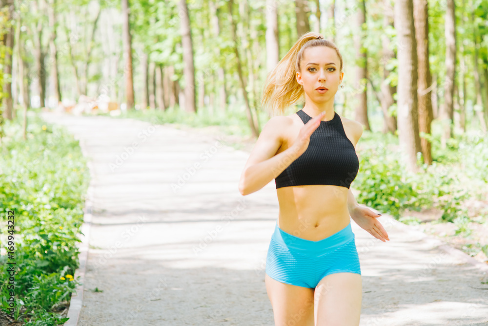 Woman jogging. Pretty young woman running in the park. Fitness outdoor