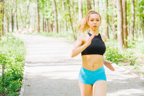 Woman jogging. Pretty young woman running in the park. Fitness outdoor