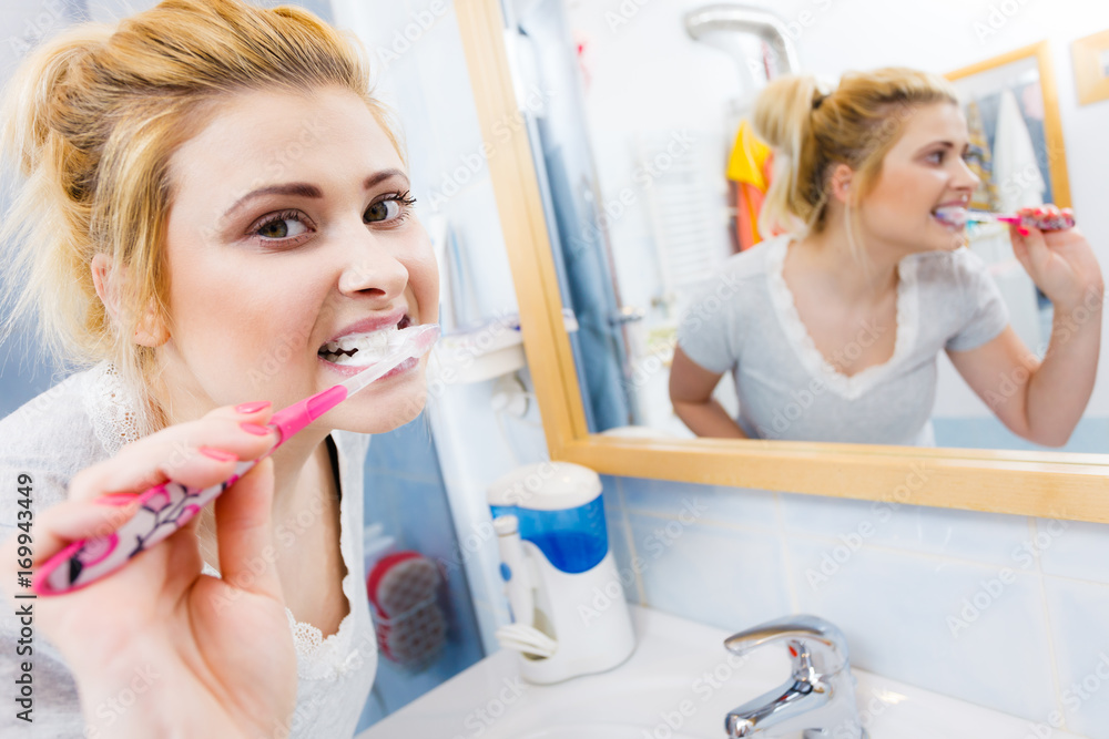 Woman brushing cleaning teeth in bathroom Woman brushing cleaning teeth in bathroom