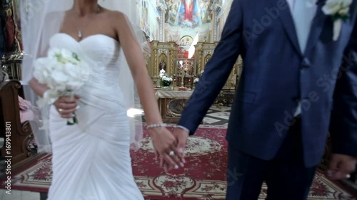 bride and groom stand in the church on the background of a beautiful iconostasis. bride and groom hold candles at the altar. close-up