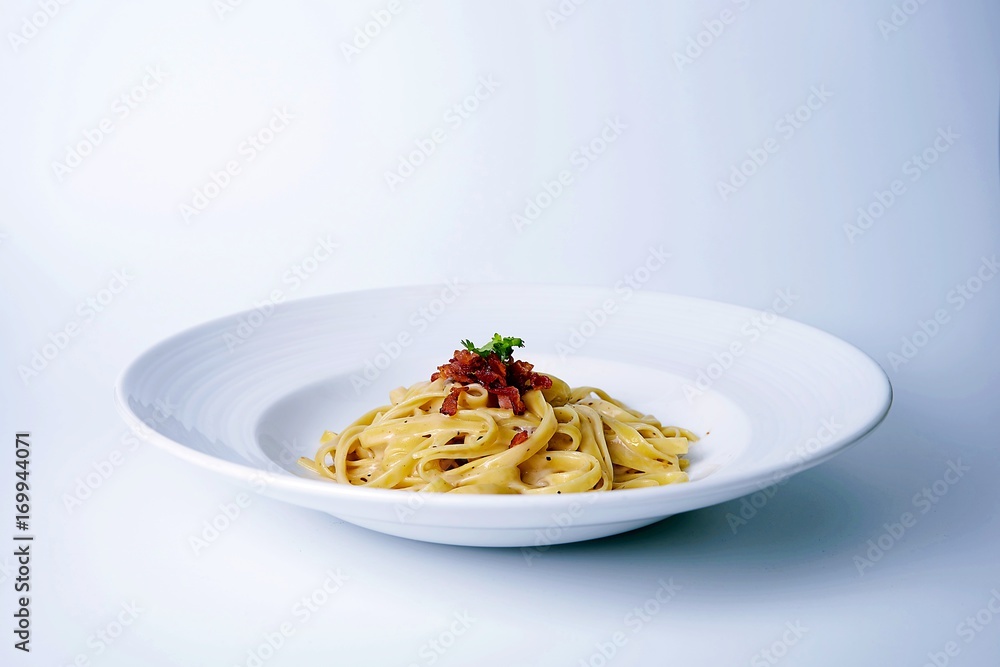 spaghetti carbonara on white plate with bacon ,white background spaghetti carbonara on white plate with bacon ,white background
