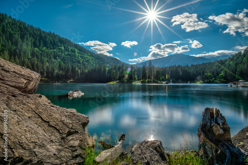 Mountain lake and dark green coniferous forest  in Switzerland before sunset