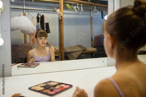 Girl doing make up while sitting in dressing room