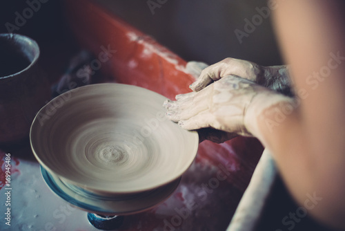 Work in a pottery workshop, womans hands creating ceramics. 
