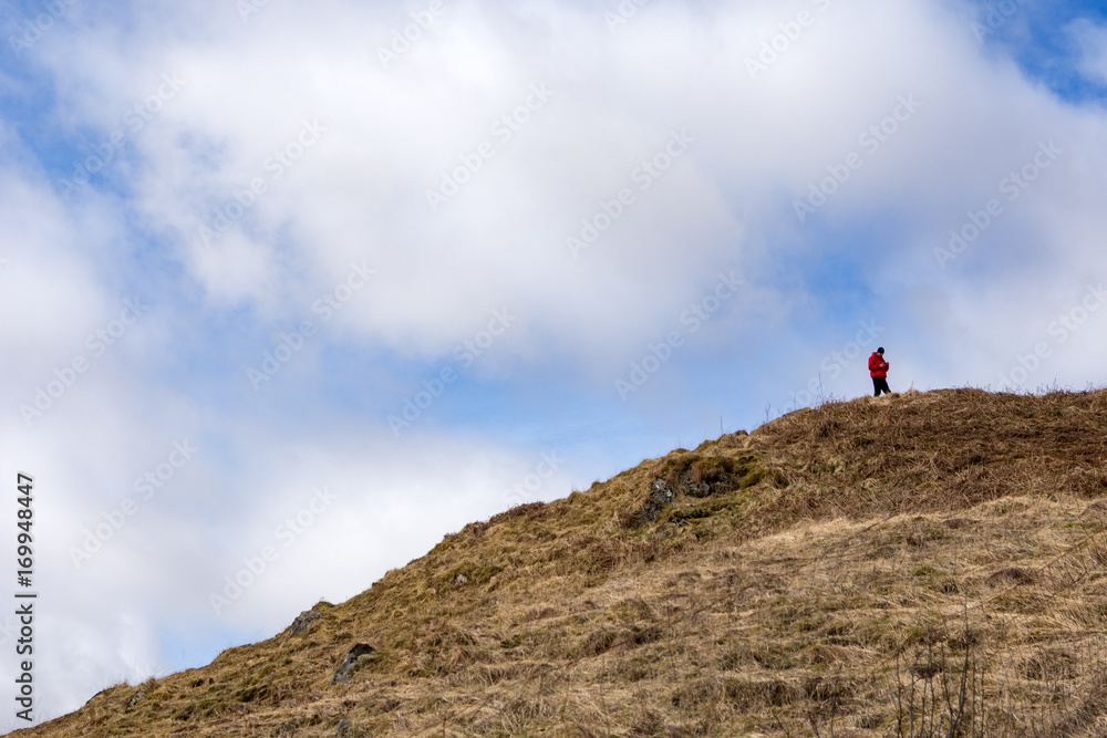 A hiker climbs a hill to get a phone signal