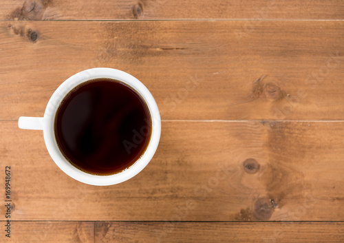 Black coffee in white cup on brown wooden background
