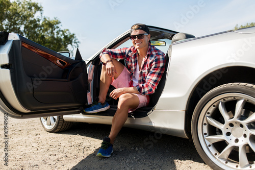 happy young man sitting in convertible car © Syda Productions