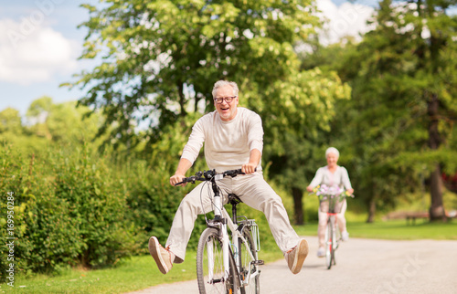 happy senior couple riding bicycles at summer park photo