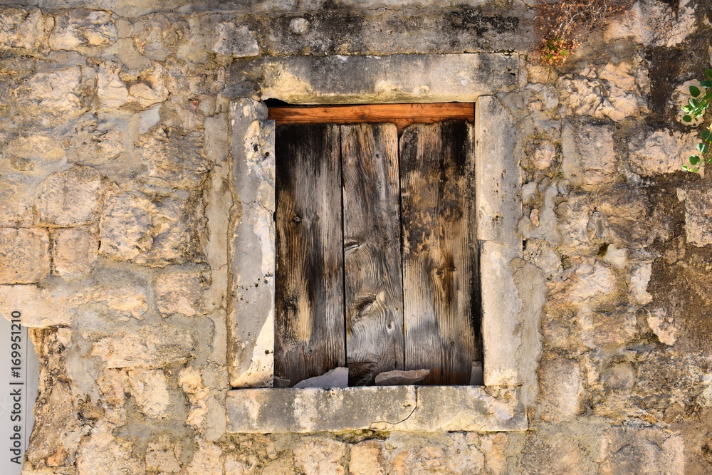 old wooden window on stone wall 