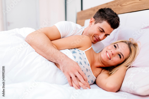 Couple having fun in bed and smiling