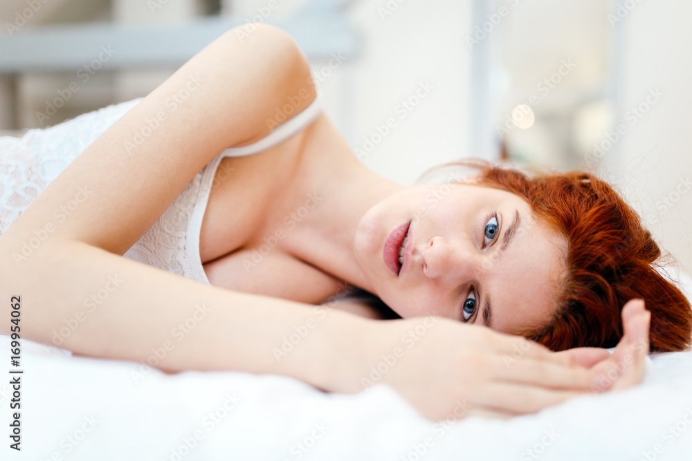 Beautiful red haired woman lying on bed Beautiful red haired woman lying on bed