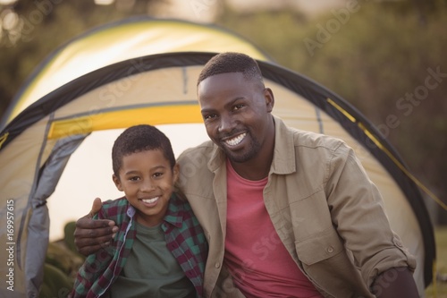 Father and son sitting in park