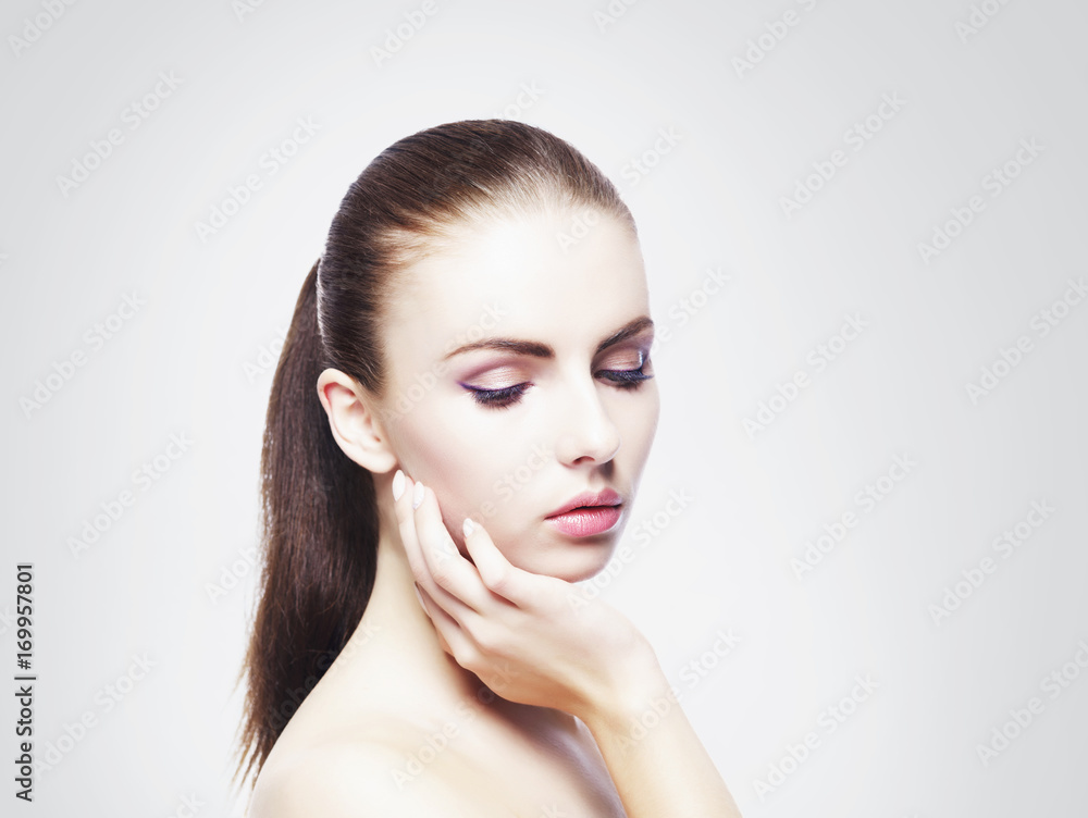 Naklejka premium Portrait of young, beautiful and healthy woman: over cold grey background. Healthcare, spa, makeup and face lifting concept.
