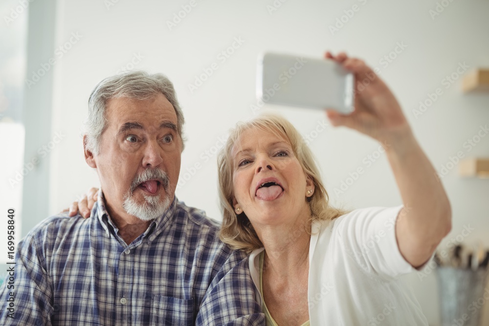 Senior couple taking a selfie in the kitchen Senior couple taking a selfie in the kitchen