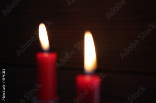 blurred red candles in front of a dark brown background