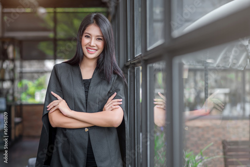 Young beautiful business woman in the coffee shop. Crossed arms.