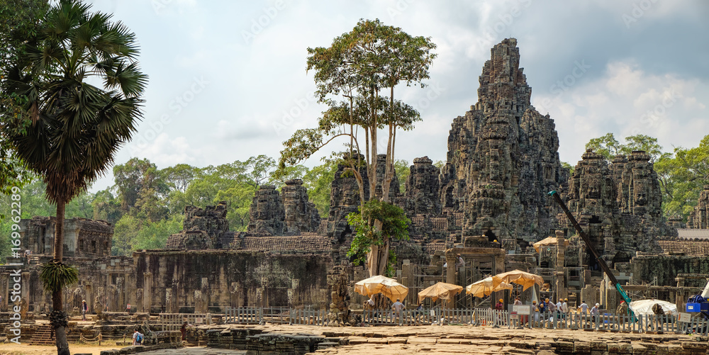 Fototapeta premium Pracownik odnawia świątynię Bayon. Starożytna architektura Khmerów do restauracji. Prasat Bayon to centralna świątynia kompleksu Angkor Thom w Siem Reap w Kambodży.