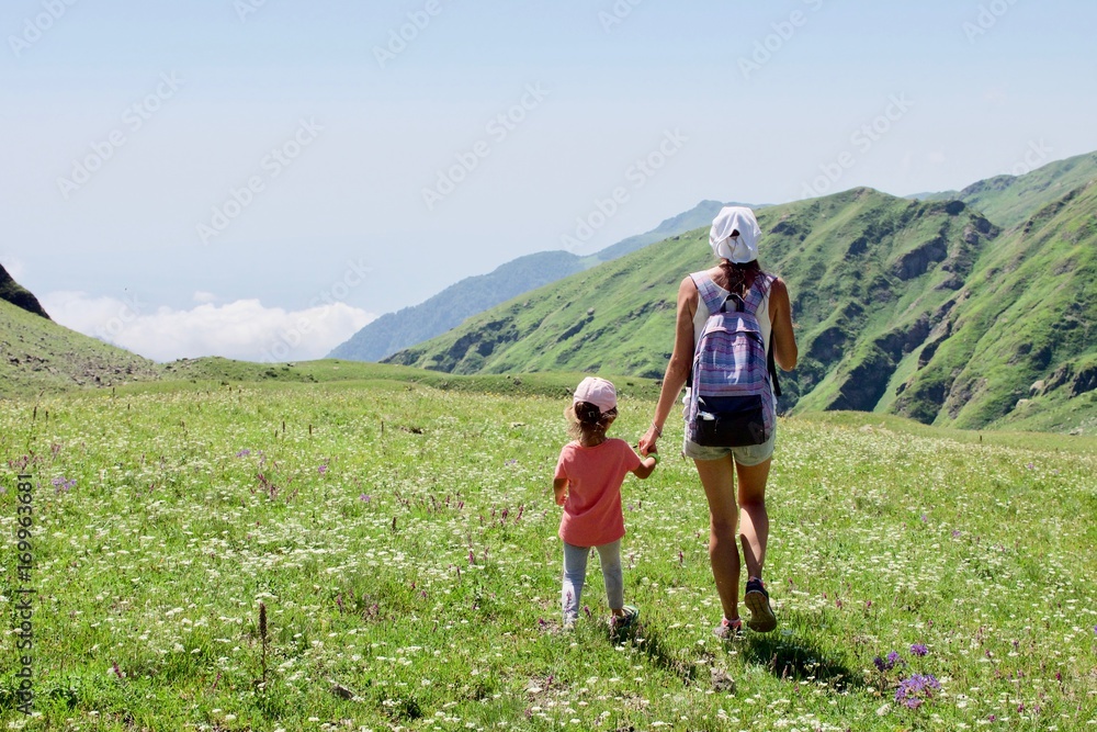 Tourist girls mother and daughter walking in mountain landscape