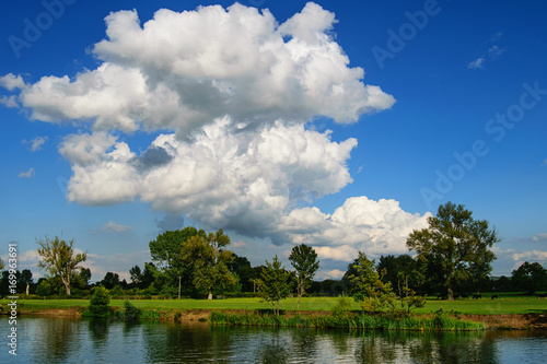 River Thames and meadow in Oxfordshire, England. Scenic summer countryside landscape.