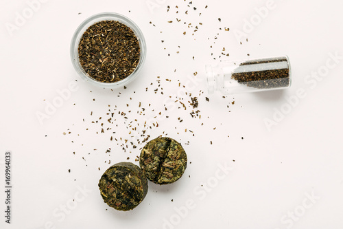 Dry green tea, compressed tea on a white background, top view photo