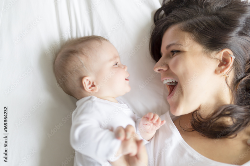 happy loving family. mother playing with her baby in the bedroom. happy loving family. mother playing with her baby in the bedroom.