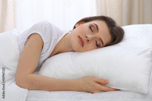 Beautiful young woman sleeping while lying in her bed and relaxing comfortably. It is easy to wake up for work or the day off. Concept of pleasant and rest reinstatement for active life © rogerphoto