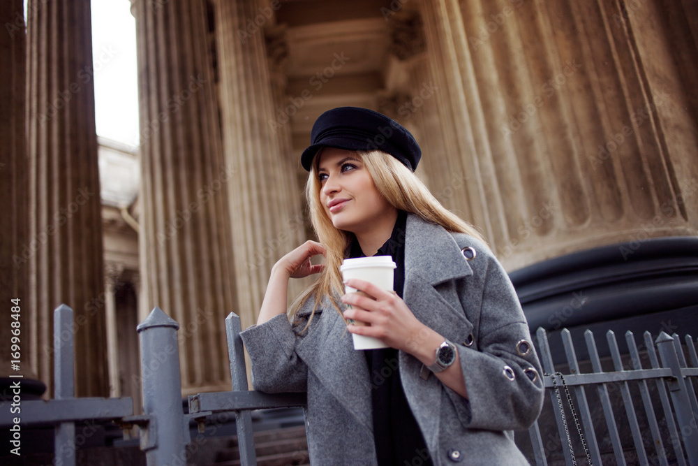 Coffee take away. Attractive blonde woman drinking coffee from a disposable Cup, outdoors