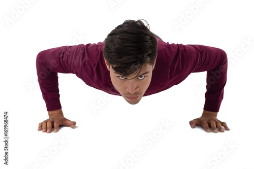 Portrait of young creative businessman doing push ups