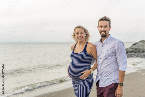 pregnant woman at beach with husband having fun